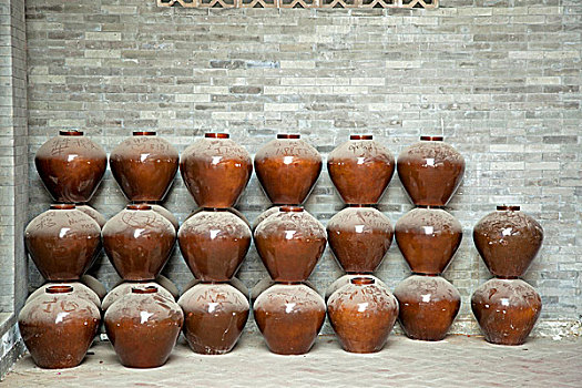 大量陶瓷罐子堆放在墙角边
