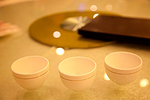 三个带金边的白色陶瓷杯排成一排