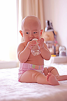 抱着奶瓶喝水的婴儿