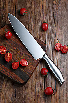 厨刀和切开的小西红柿放在案板上