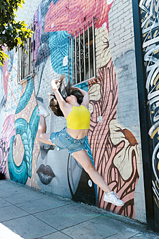 在涂鸦墙前跳舞的女孩