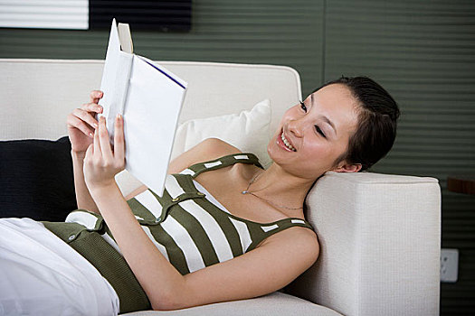 一个女人躺在沙发上看书