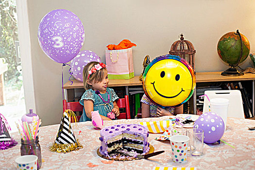 两个女孩,坐,生日派对,桌子,蛋糕,玩,笑脸,气球