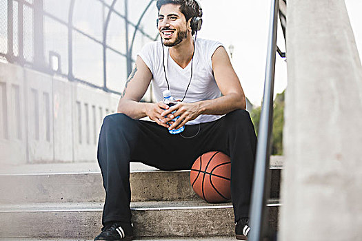 男青年,篮球手,坐,步行桥,听,耳机