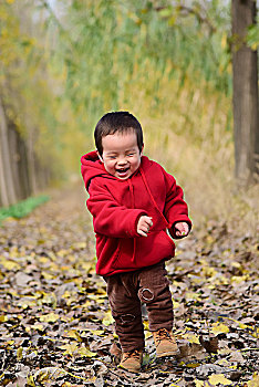 秋天树林里开心的小男孩