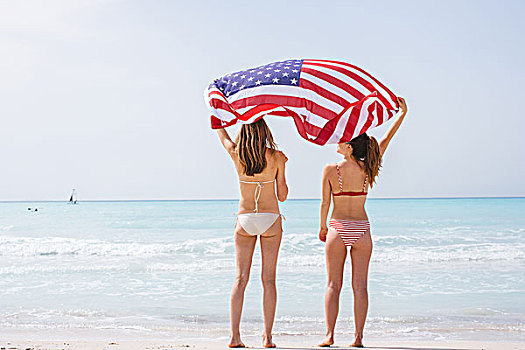 后视图,两个,美女,朋友,穿,比基尼,海滩,拿着,向上,美国国旗
