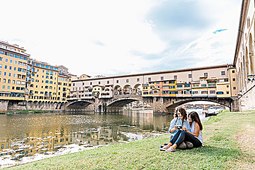 女同性恋伴侣,坐,一起,河边,看,数码相机,正面,维奇奥桥,阿尔诺河,佛罗伦萨,托斯卡纳,意大利
