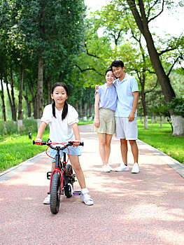 年轻的父母教孩子骑自行车