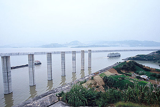 长江三峡三峡大坝五级船闸靠船柱与刚出船闸的客船