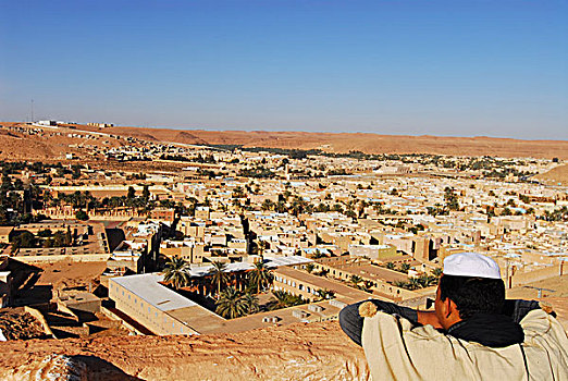 algeria,ben,isguen,view,of,a,man,looking,at,historic,village,against,clear,blue,sky