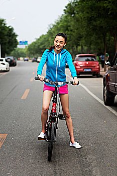 青年女性在马路上骑自行车